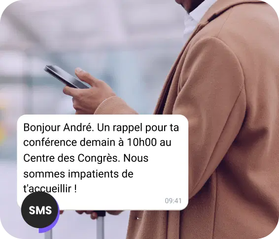 Un homme se promène dans la rue en lisant un SMS de rappel pour son rendez-vous.