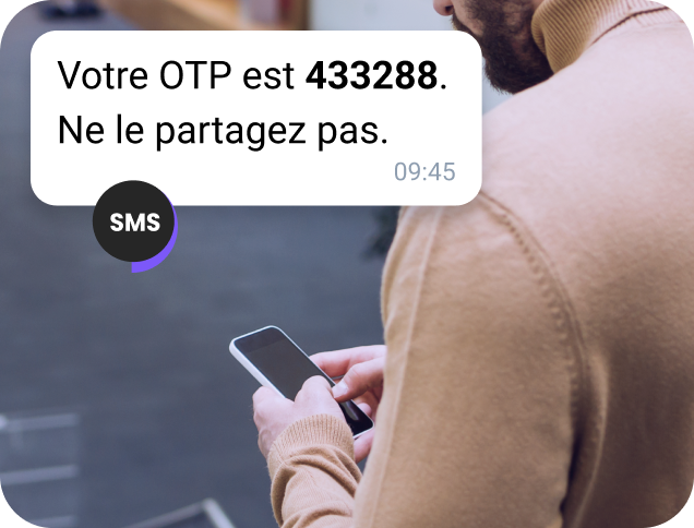 Un homme âgé sous la neige vérifie son téléphone pour obtenir des informations sur l'emplacement via un message WhatsApp professionnel.
