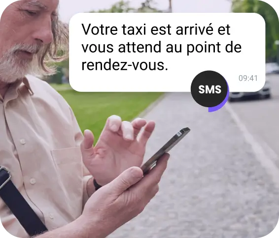 Une jeune femme avec une casquette rouge consulte un message professionnel sur WhatsApp sur son téléphone.