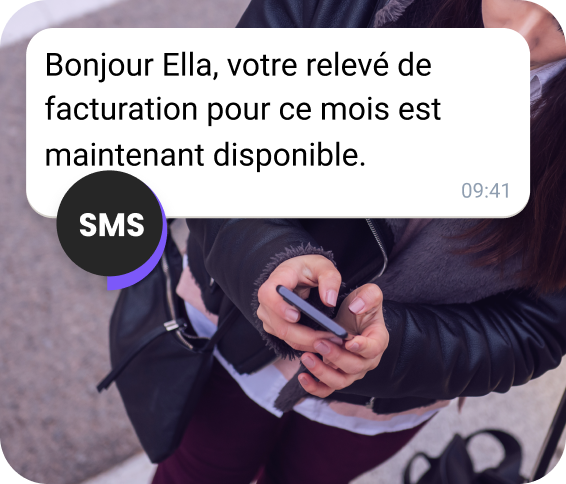 Une jeune femme dans la rue reçoit un relevé de facturation par SMS.